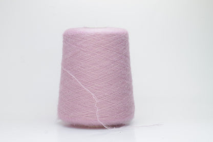 Close-up of fluffy Rosa kid mohair and silk blend yarn, subtly lustrous with a soft halo, gently twisted into a fine, delicate thread.