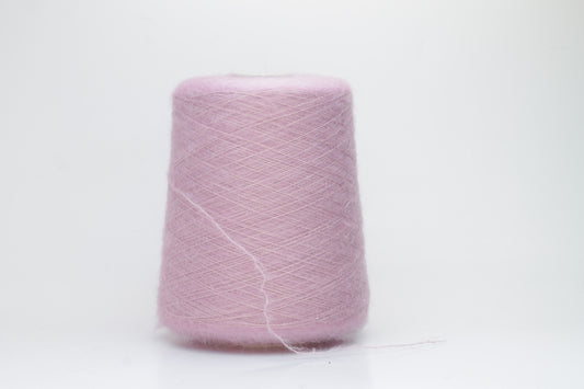 Close-up of fluffy Rosa kid mohair and silk blend yarn, subtly lustrous with a soft halo, gently twisted into a fine, delicate thread.