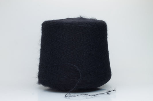 Close-up of fluffy Black kid mohair and silk blend yarn, subtly lustrous with a soft halo, gently twisted into a fine, delicate thread.