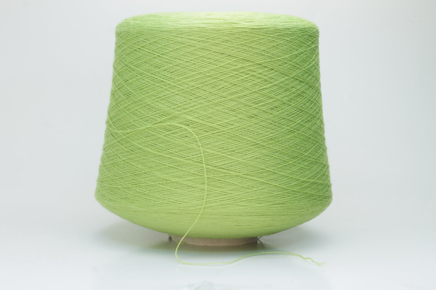 Close-up shot of the '100% Merino Toolegno 1900 Nm 2/30 Green Premium Yarn', showcasing the fluffy green fibers and a prominent ply twist, highlighting the dense thread structure and subtle sheen.
