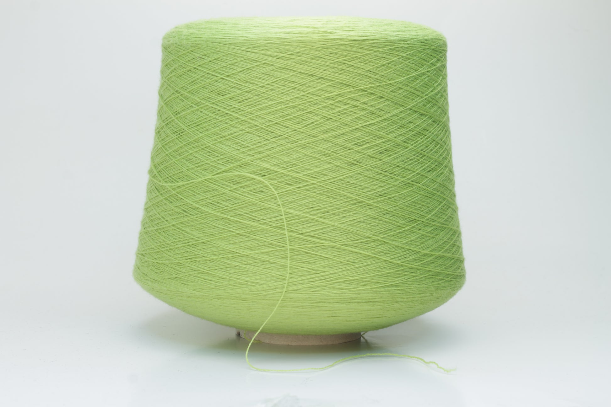 Close-up shot of the '100% Merino Toolegno 1900 Nm 2/30 Green Premium Yarn', showcasing the fluffy green fibers and a prominent ply twist, highlighting the dense thread structure and subtle sheen.