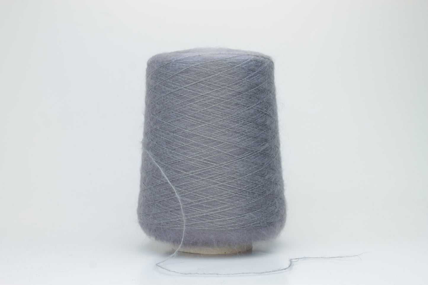 Close-up of fluffy Smog (Gray) kid mohair and silk blend yarn, subtly lustrous with a soft halo, gently twisted into a fine, delicate thread.