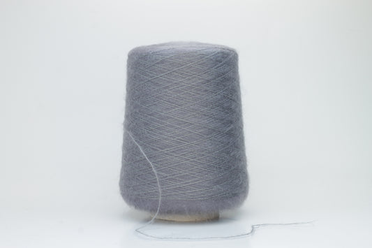 Close-up of fluffy Smog (Gray) kid mohair and silk blend yarn, subtly lustrous with a soft halo, gently twisted into a fine, delicate thread.