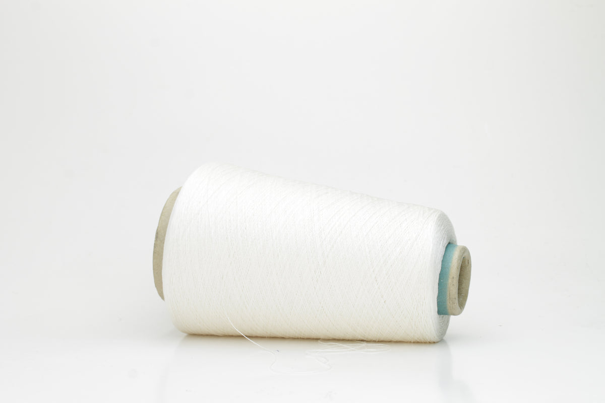 Close-up of a skein of lustrous, pure white silk yarn, tightly plied with a smooth, radiant finish, reflecting light softly.