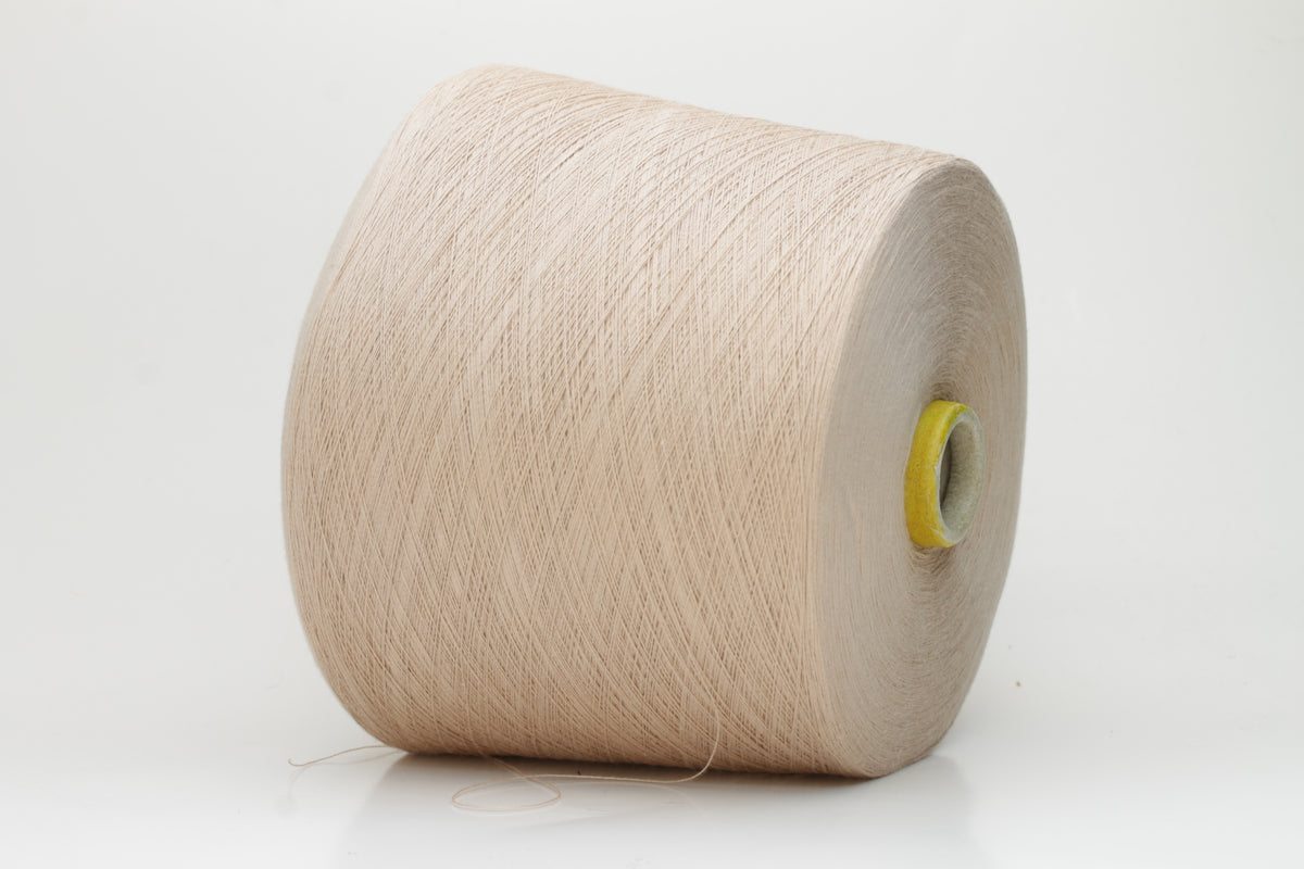 Close-up of a vibrant, Powder Pink Beige cotton yarn. The smooth, tightly twisted 2-ply thread exhibits a subtle sheen and deep, saturated color.