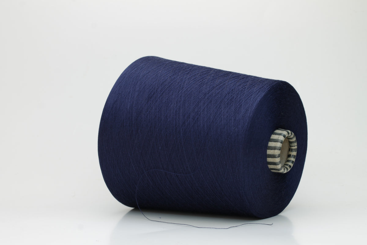 Close-up of a meticulously twisted, fine-gauge cotton yarn in a deep, lustrous classic navy blue with a subtle sheen.