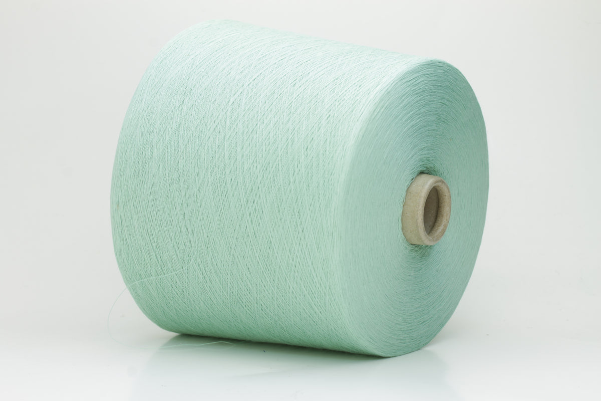 A finely spun, smooth cotton yarn in a delicate pastel mint green color, showing a subtle sheen and tightly plied structure.