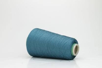 A skein of luxurious 100% pure silk yarn in a deep, shimmering petrol blue, displaying a smooth, finely spun single ply with a high, lustrous sheen.