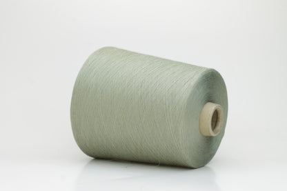 A finely spun, lustrous two-ply cotton yarn in a muted, earthy soft sage green, showcasing a gentle twist and smooth finish.