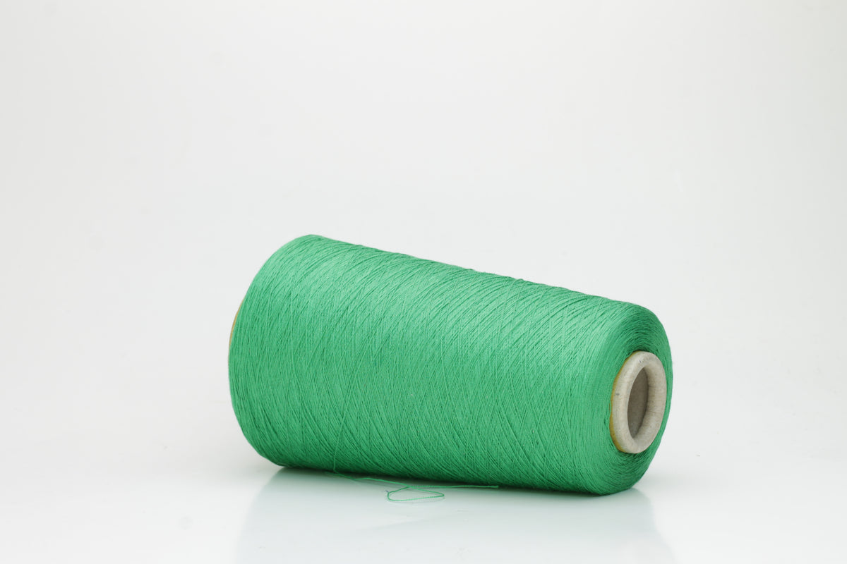 Close-up of a single strand of lustrous, single-ply 100% silk yarn in a vibrant mint green, showcasing its smooth texture and elegant sheen.