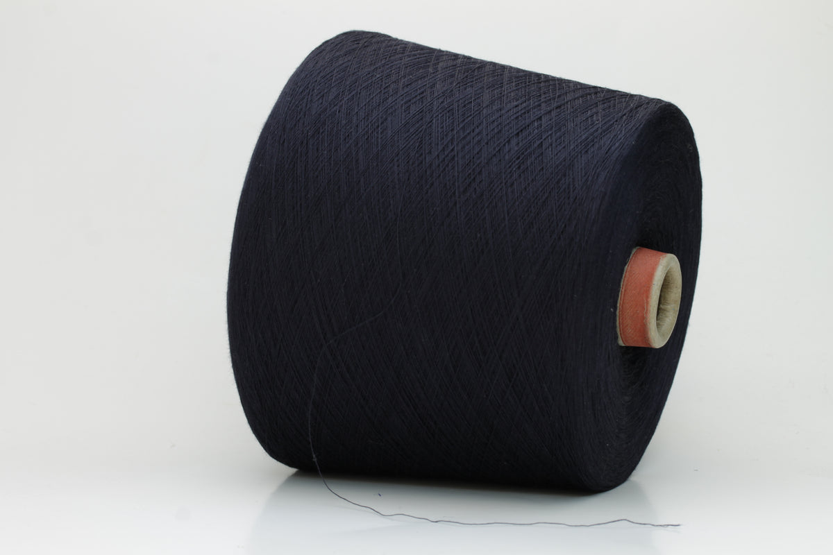 A skein of finely spun, smooth 100% cotton yarn in a deep Midnight Navy, showing a subtle sheen and even, uniform twist.
