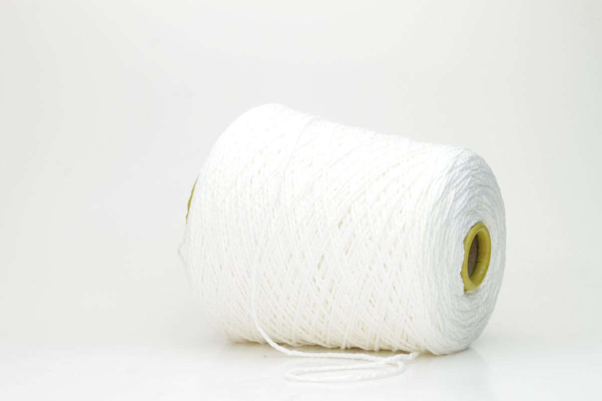 Close-up of a pristine white, single-ply cotton yarn with a smooth, even texture and subtle matte sheen, gently coiled.