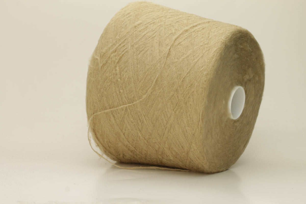 Luxurious, pristine Beige single-ply silk yarn with a smooth, uniform texture and a delicate sheen, softly coiled.