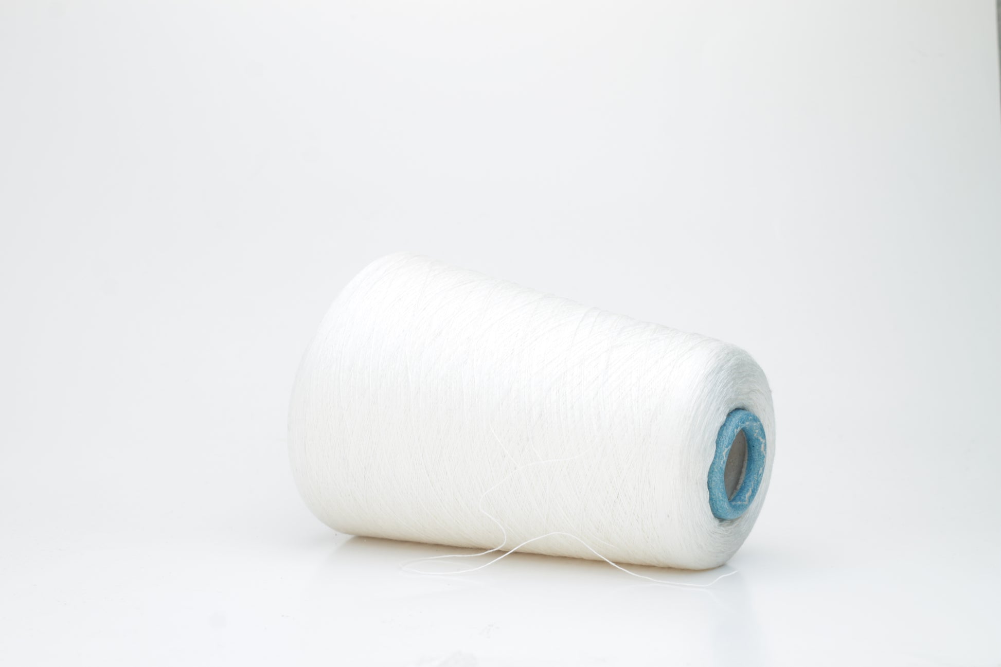 Fine, pure white silk yarn, tightly twisted with a subtle, radiant sheen. Smooth texture, uniform ply, elegant thread structure for delicate projects.