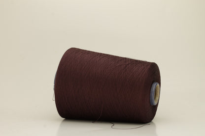 Close-up of a deep, rich espresso brown silk yarn wound in a neat cake, showcasing its smooth, lustrous surface and fine, even ply twist. The individual strands reflect light softly.