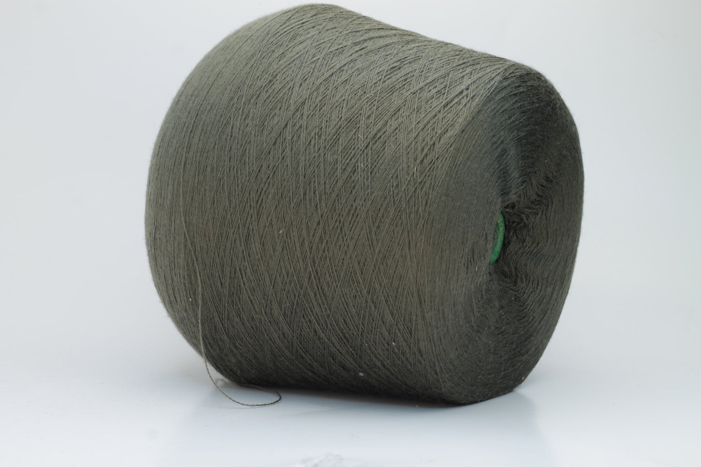 Close-up shot of a vibrant green Merino 100% Cashwool yarn skein. The yarn features a tight, dense ply twist and a subtle sheen, with visible individual strands creating a rich, textured effect.
