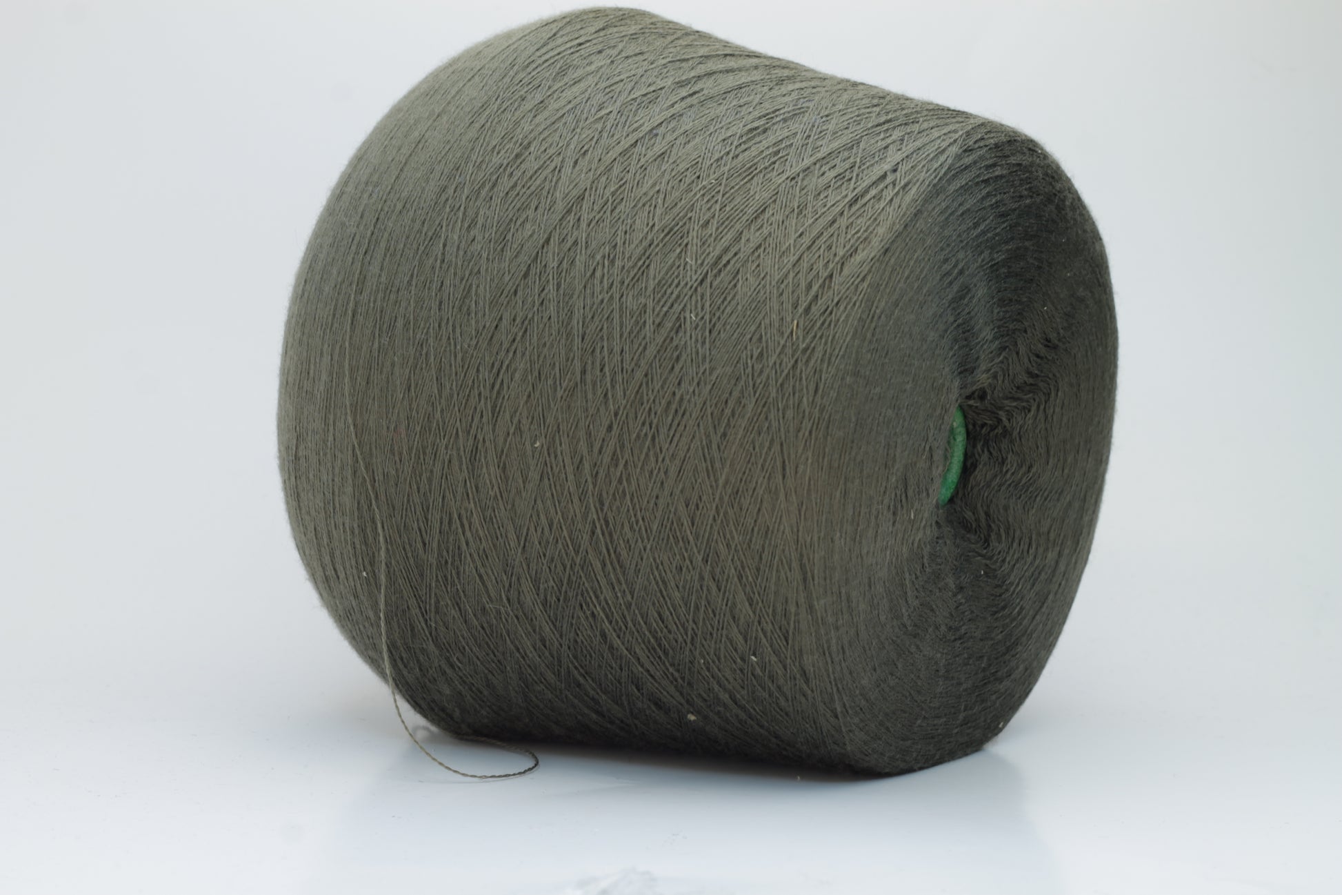 Close-up shot of a vibrant green Merino 100% Cashwool yarn skein. The yarn features a tight, dense ply twist and a subtle sheen, with visible individual strands creating a rich, textured effect.