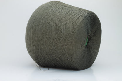 Close-up shot of a vibrant green Merino 100% Cashwool yarn skein. The yarn features a tight, dense ply twist and a subtle sheen, with visible individual strands creating a rich, textured effect.