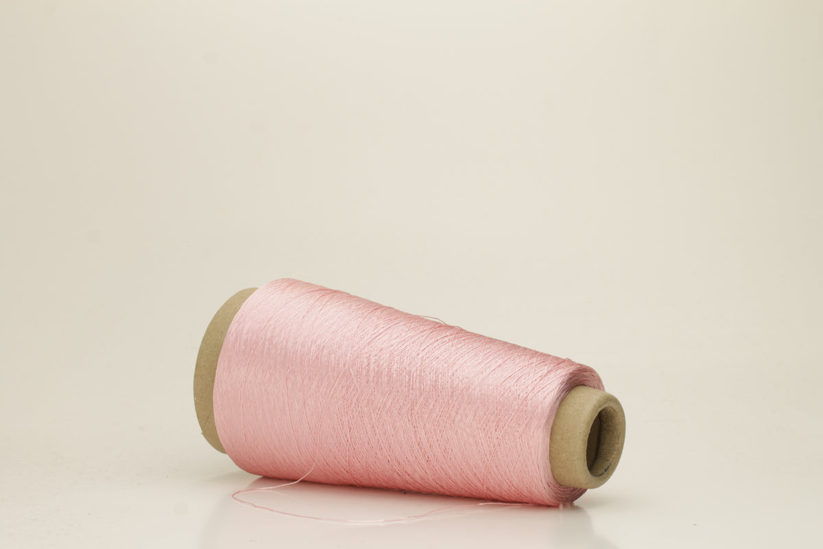 Close-up of pristine Rosa, finely plied 100% silk yarn, twisted smoothly to reveal a high, lustrous sheen and uniform structure.