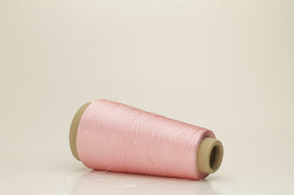 Close-up of pristine Rosa, finely plied 100% silk yarn, twisted smoothly to reveal a high, lustrous sheen and uniform structure.