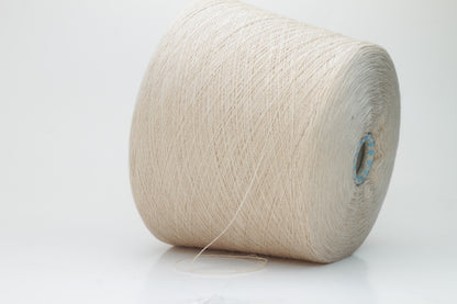 Close-up shot of creamy beige merino yarn, featuring a tight ply twist and a subtle sheen. The fibers exhibit exceptional fluffiness and texture, ideal for intricate knitting patterns.