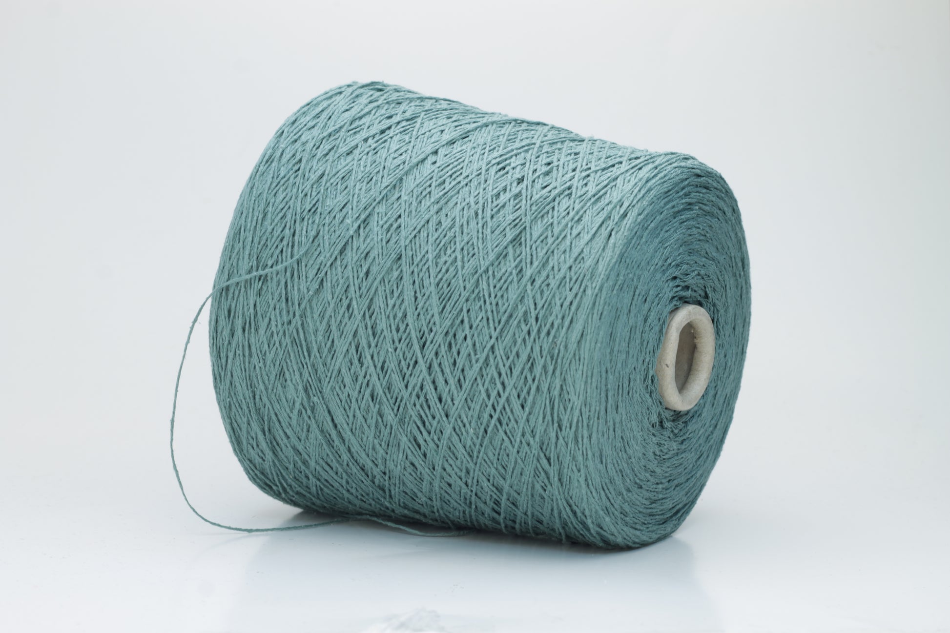 Close-up shot of shimmering silk bourette yarn in a rich verdone color. The multi-plied strands show subtle twist and depth, with a delicate sheen and fluffy texture.
