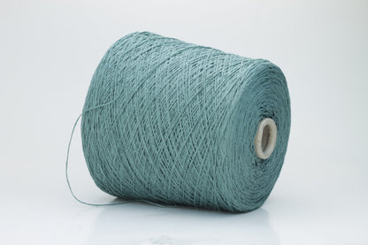 Close-up shot of shimmering silk bourette yarn in a rich verdone color. The multi-plied strands show subtle twist and depth, with a delicate sheen and fluffy texture.