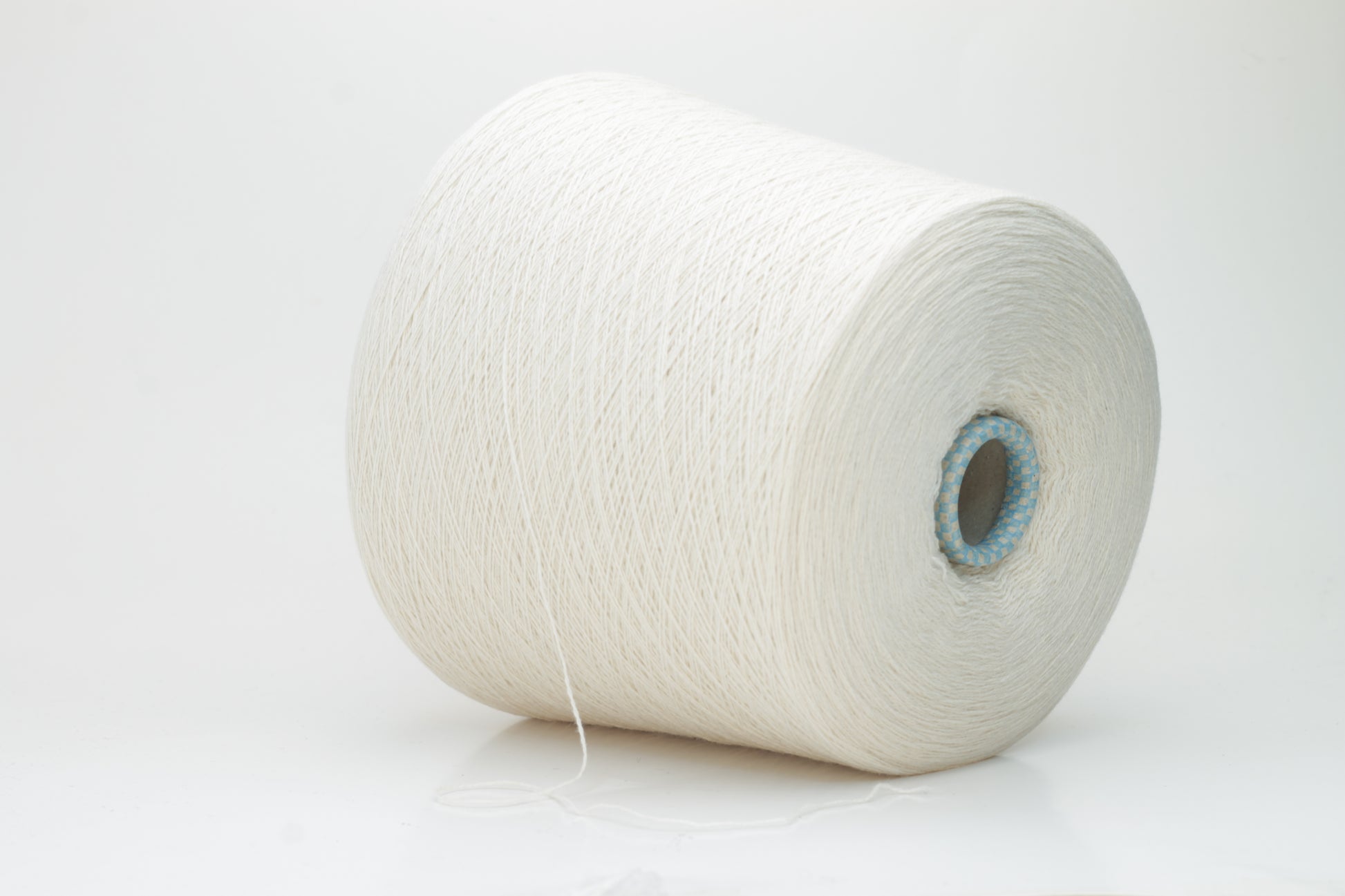 Close-up of a finely spun, 2-ply cashmere yarn skein in a delicate, warm champagne beige. Features a soft, subtle napped texture and elegant sheen.