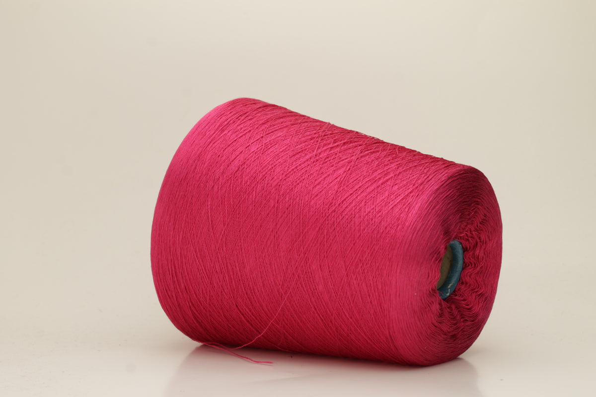 Close-up of vibrant hot pink 100% pure silk yarn, showcasing its fine, smooth single ply and high, natural luster reflecting light beautifully.