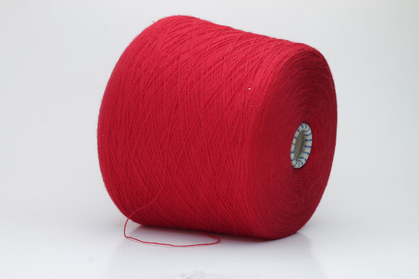 Close-up shot of vibrant red Zegna Baruffa Merino 100% Cashwool yarn, displaying a tight 2/30 Nm ply twist with deep color saturation and a slightly fluffy texture.