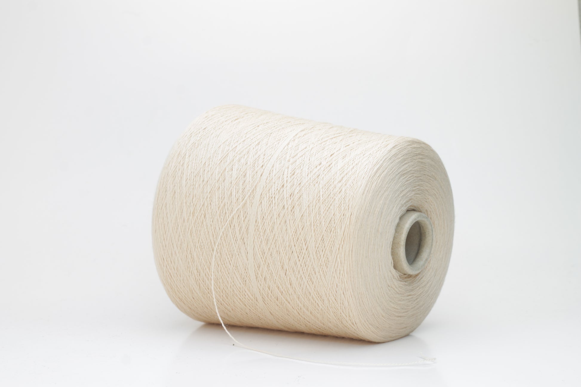 Close-up of luxurious Beige Merino wool yarn, two-ply twist with a soft, subtle sheen, and fine, consistent thread structure.