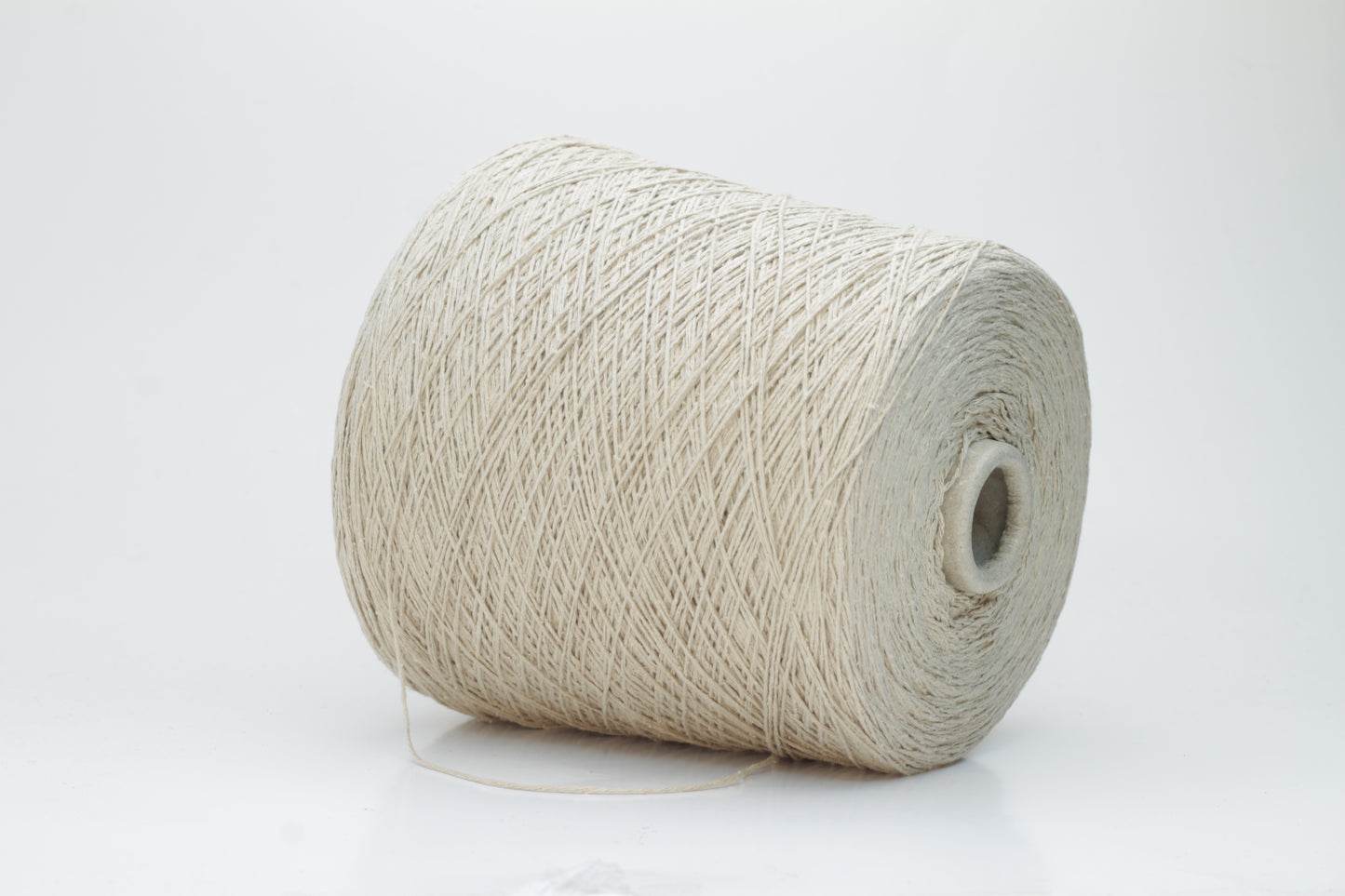 Close-up of a skein of natural beige 100% silk bourette yarn, showing its characteristic slubby, textured, slightly uneven threads.