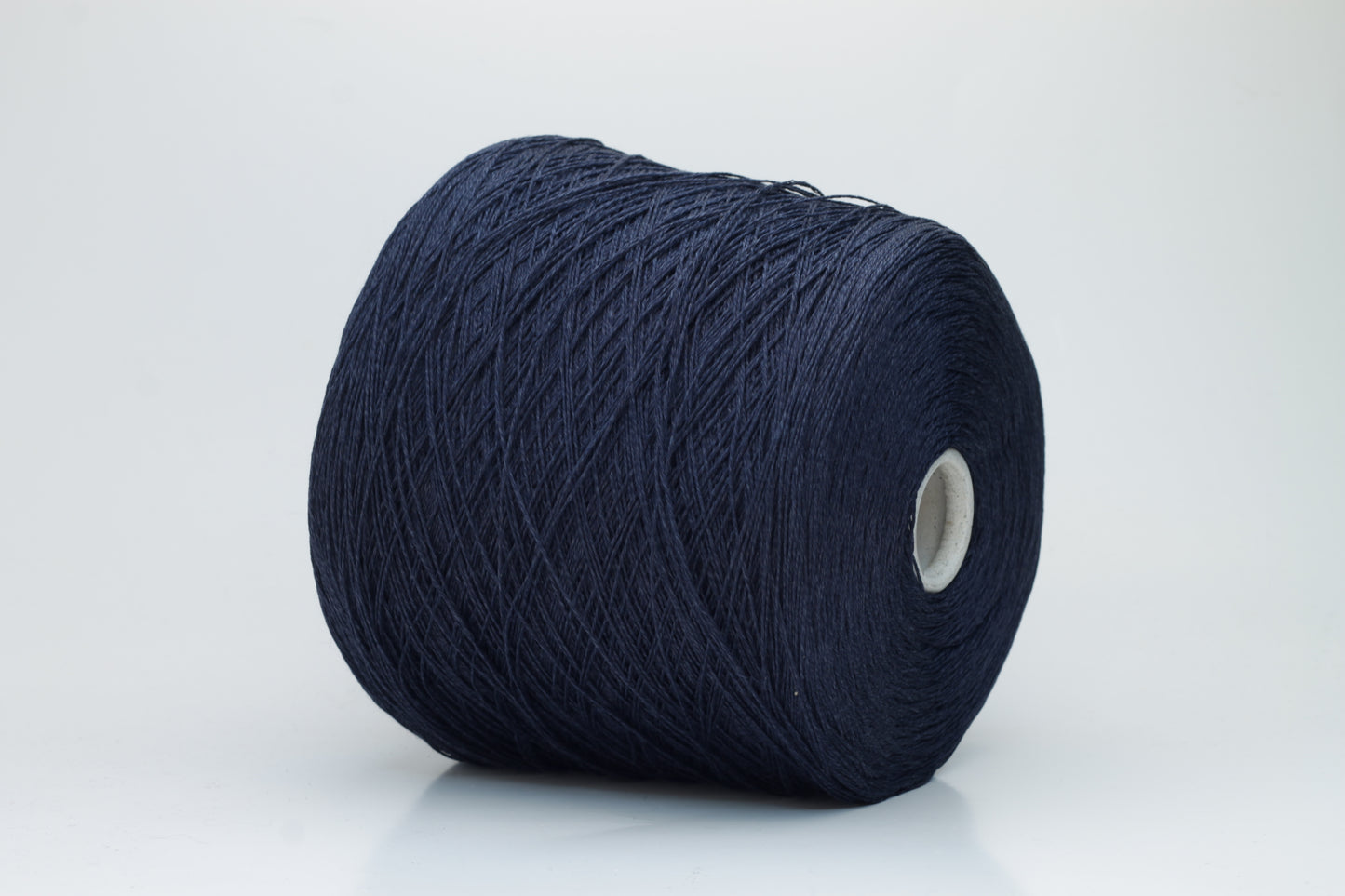 Close-up of pristine Navy linen and viscose blend yarn, softly twisted with a subtle sheen, showcasing its fine, smooth texture.