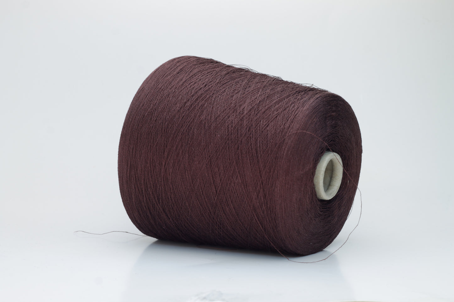 Close-up of a tightly twisted, fine-gauge yarn in a deep, warm earthy brown color, showing a subtle natural sheen from the linen fibers.