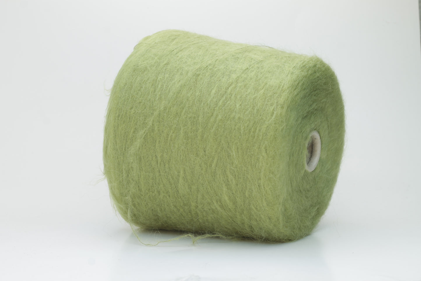 Close-up shot of vibrant green SuperKidMohair yarn showcasing a tight ply twist and rich fiber structure, revealing its inherent fluffiness and subtle sheen.