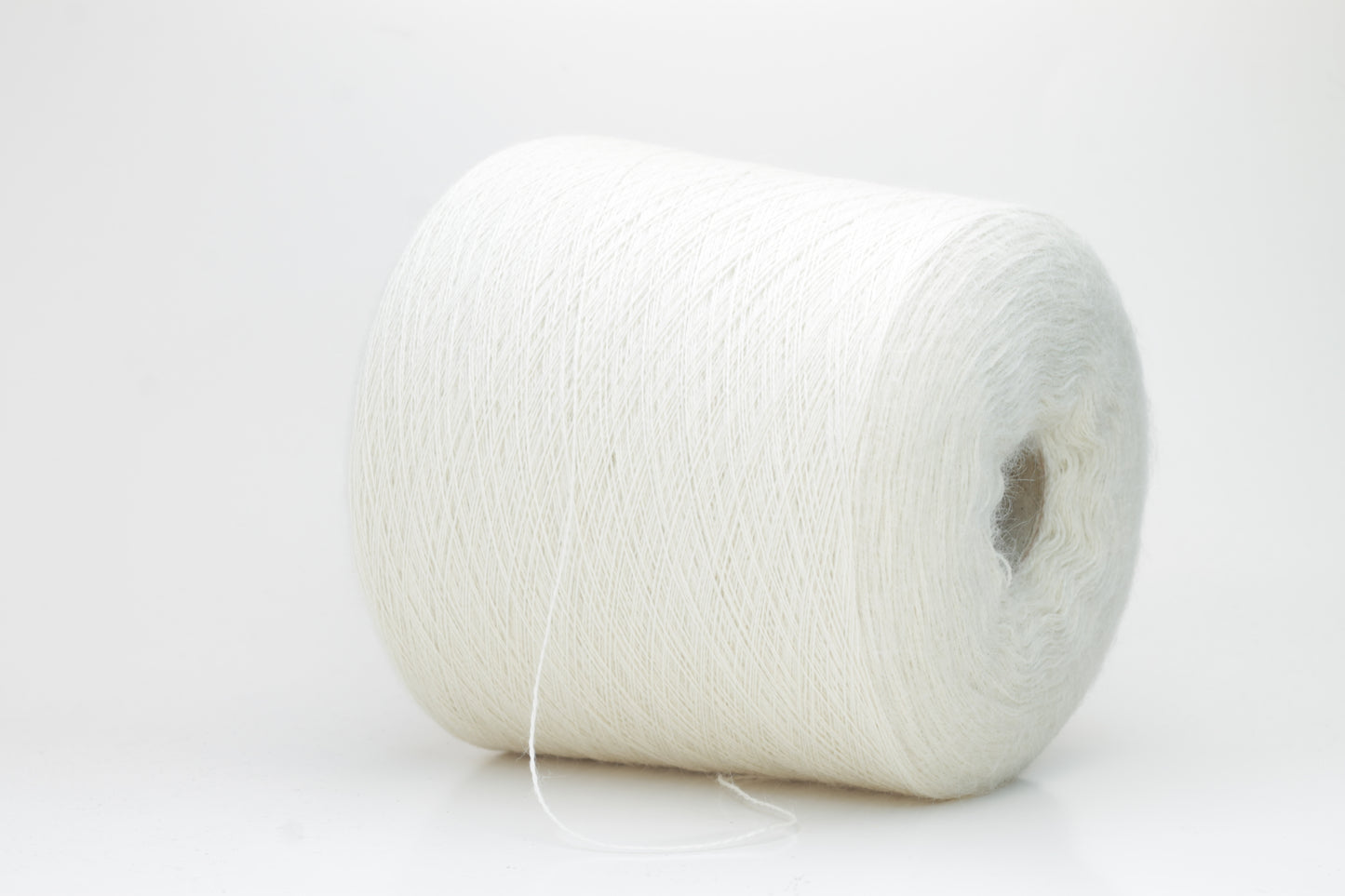 A close-up shot of a single ply, pure white alpaca yarn, softly twisted, showcasing its ethereal fluffiness and subtle sheen against a neutral background.