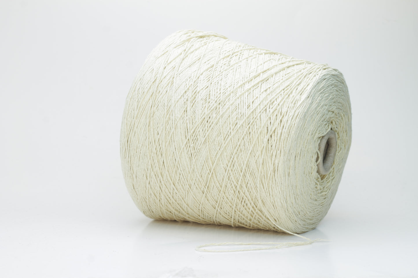 Close-up of creamy 'Giallino' Silk Bourette yarn, showcasing its incredibly fine ply twist and subtle sheen. The yarn has a smooth, almost liquid texture with abundant fluffiness.