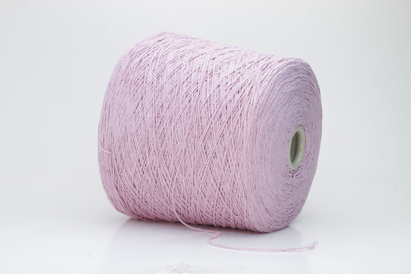 Close-up of luxurious silk bourette yarn in a vibrant 'Rosa Antic' shade. The thread exhibits a fine ply twist with a subtle sheen and remarkable fluffiness, showcasing the yarn’s rich color depth.