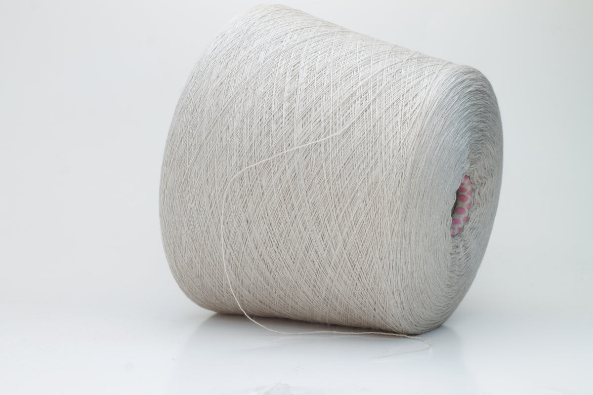 Close-up shot of a vibrant, creamy beige merino yarn skein, showcasing its subtle sheen, delicate ply twist, and the fine, soft texture of the fibers.