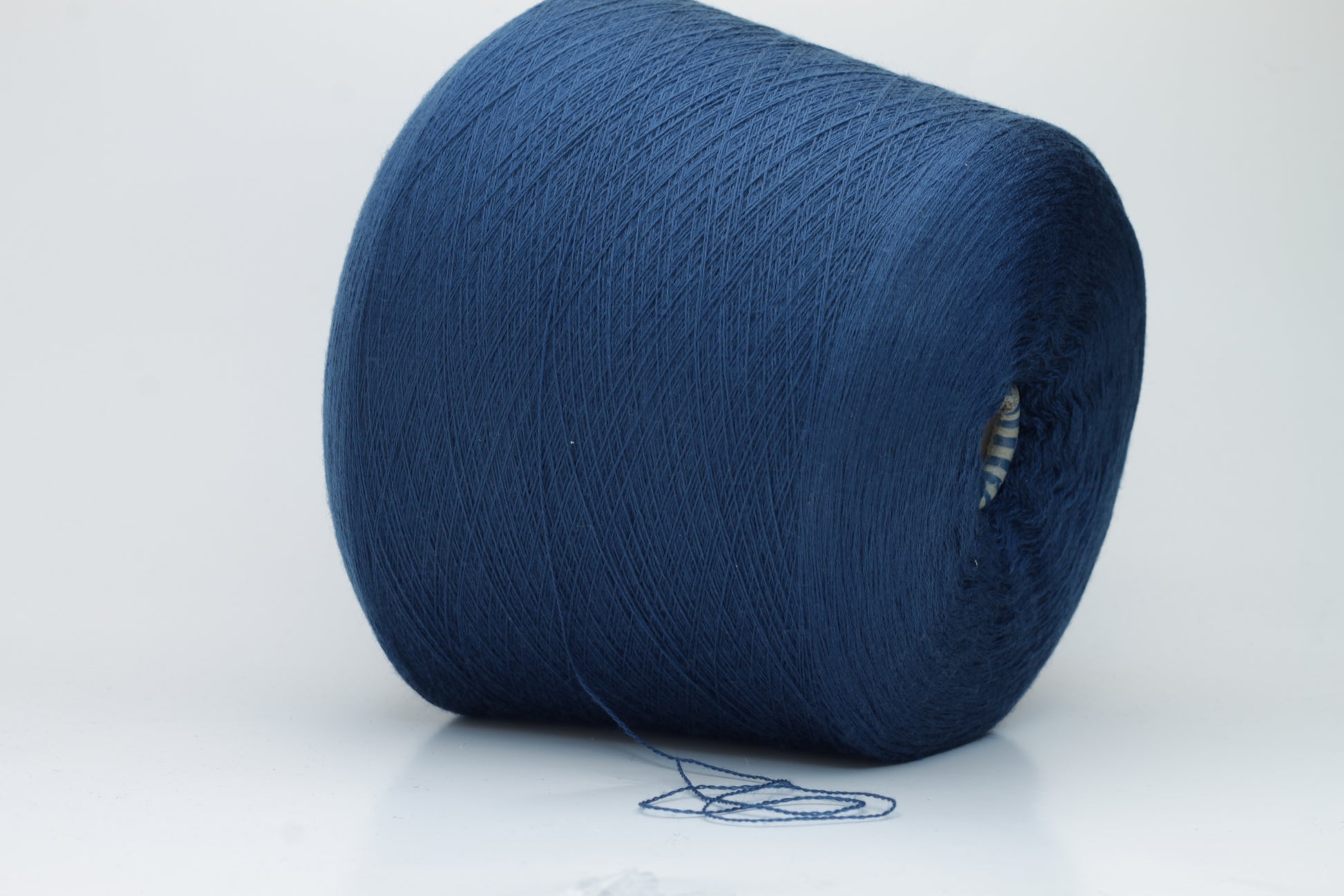 Close-up view of ZEGNA BARUFFA Merino 100% Cashwool, Nm 2/30, Color Blue. The yarn showcases a tight, even ply twist with a dense thread structure and subtle sheen reflecting the deep blue color, presenting a fluffy and inviting texture.