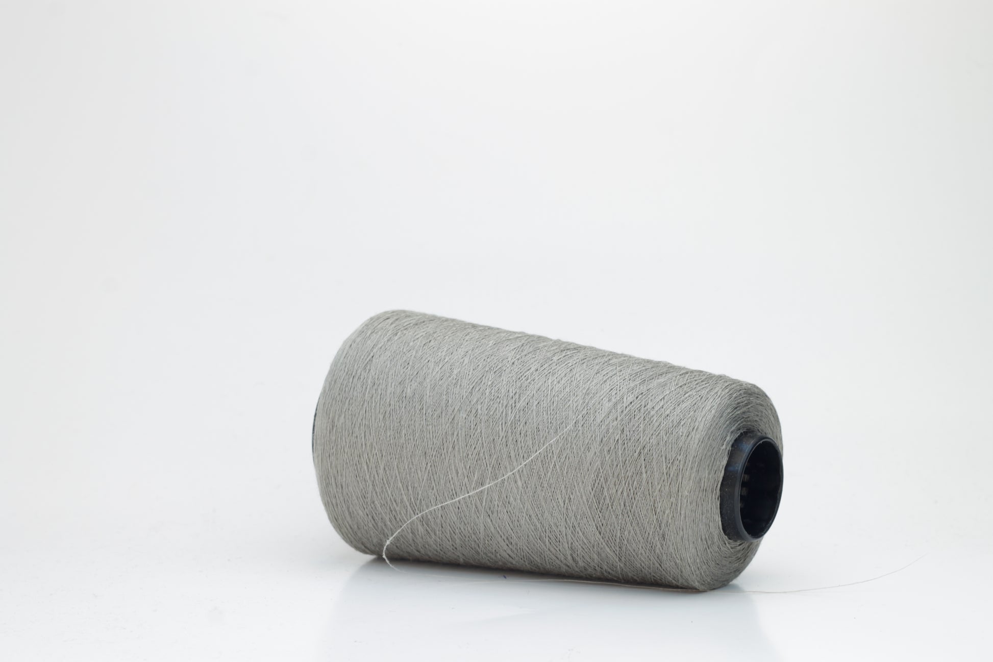 Fine, single-ply linen yarn in a rich Silver Gray. Reveals a crisp texture and subtle natural sheen, typical of pure linen fiber.