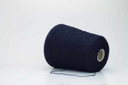 A tightly spun two-ply yarn, rich navy blue, made from exceptionally soft, fine cashmere fibers with a slight halo, presented as a graceful hank.