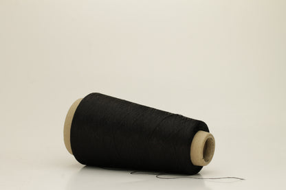 Close-up of pristine Black, finely plied 100% silk yarn, twisted smoothly to reveal a high, lustrous sheen and uniform structure.