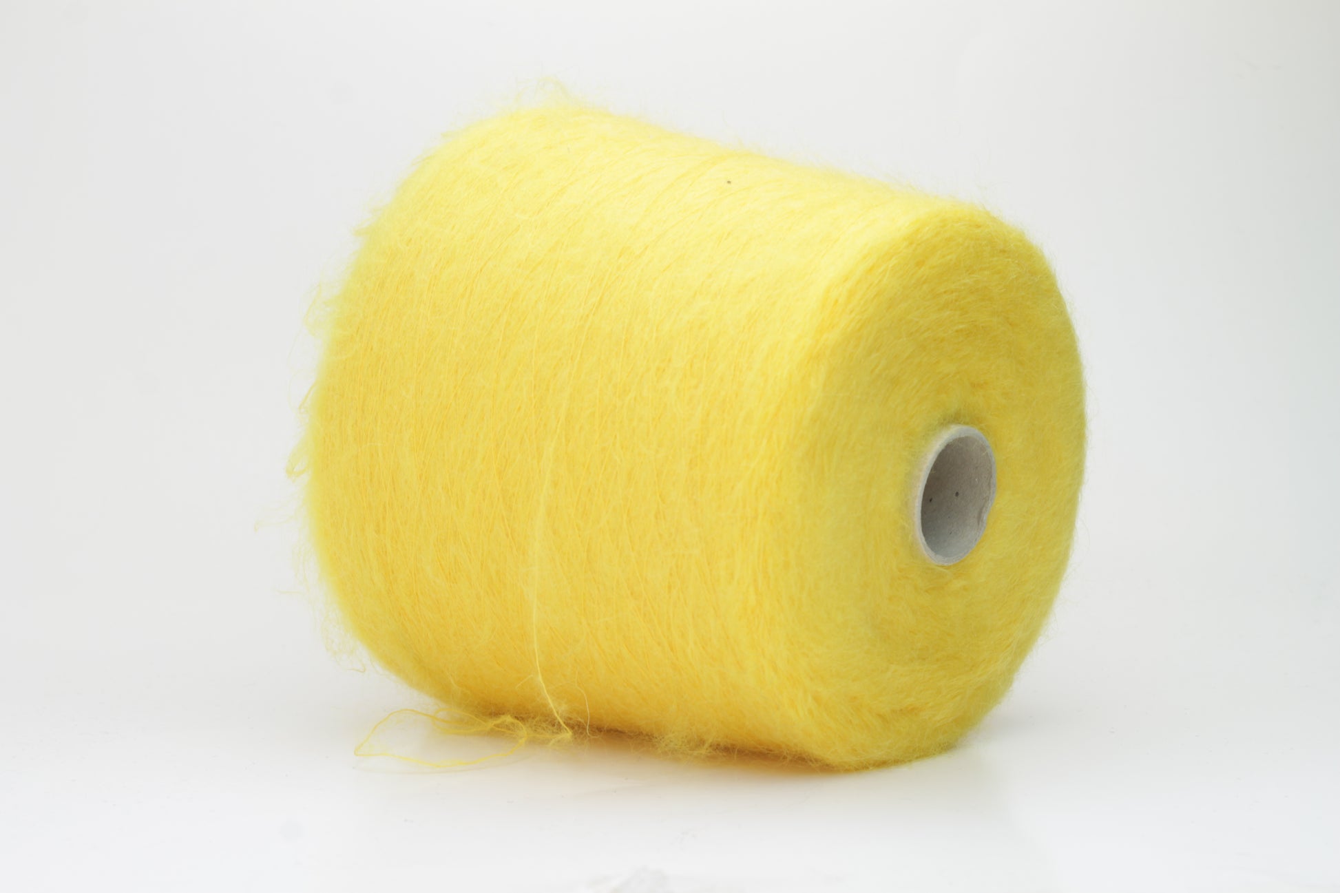 Close-up shot of vibrant yellow SuperKidMohair yarn showing a tight ply twist and soft, fluffy texture. The fibers exhibit a subtle sheen with excellent color depth.
