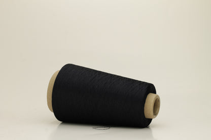 A skein of fine, single-ply 100% silk yarn, lustrous with a deep, rich dark midnight blue hue, reflecting light softly.