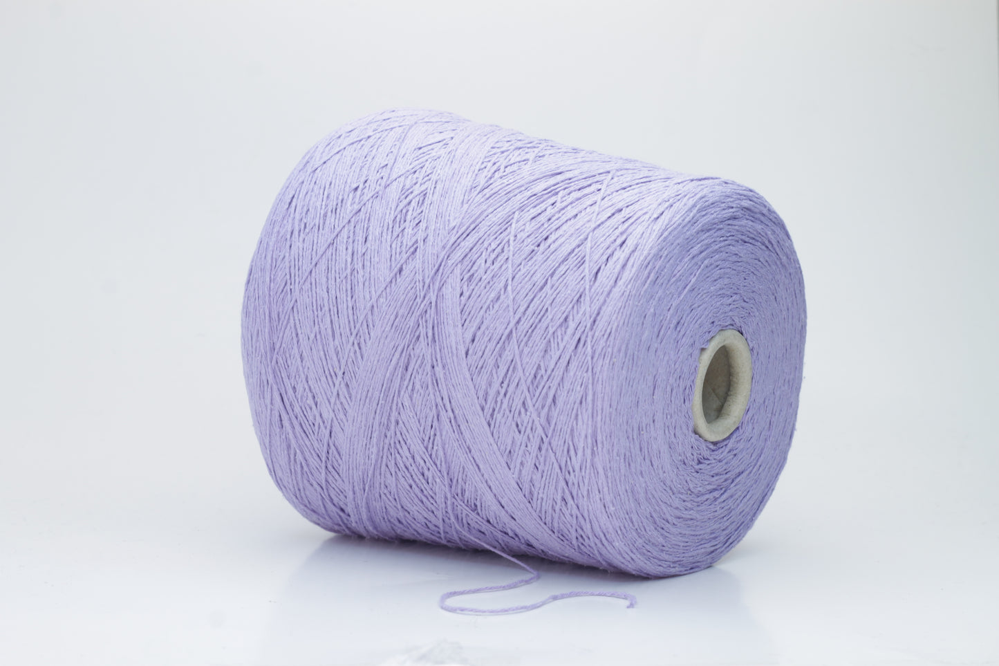 Close-up of a single strand of matte lavender silk bourette yarn, showcasing its natural slub texture and soft, nubbly appearance, coiled gently.