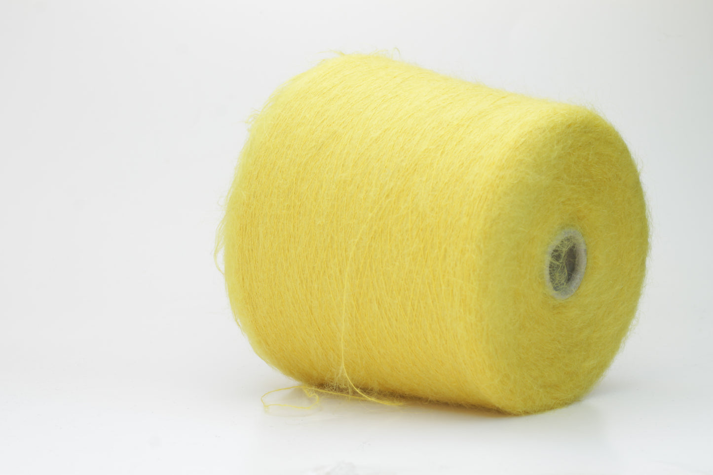 Close-up view of vibrant yellow SuperKidMohair yarn in a loose, fluffy ply twist. The yarn exhibits significant sheen and fluffiness, with distinct individual fibers visible.