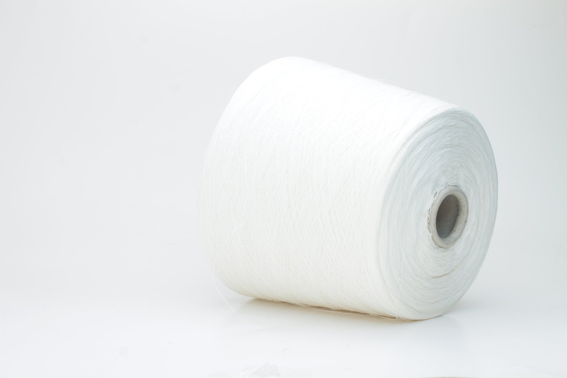 A bright white, single-ply yarn, subtly twisted, revealing the natural texture of linen fibers with a soft, understated sheen.