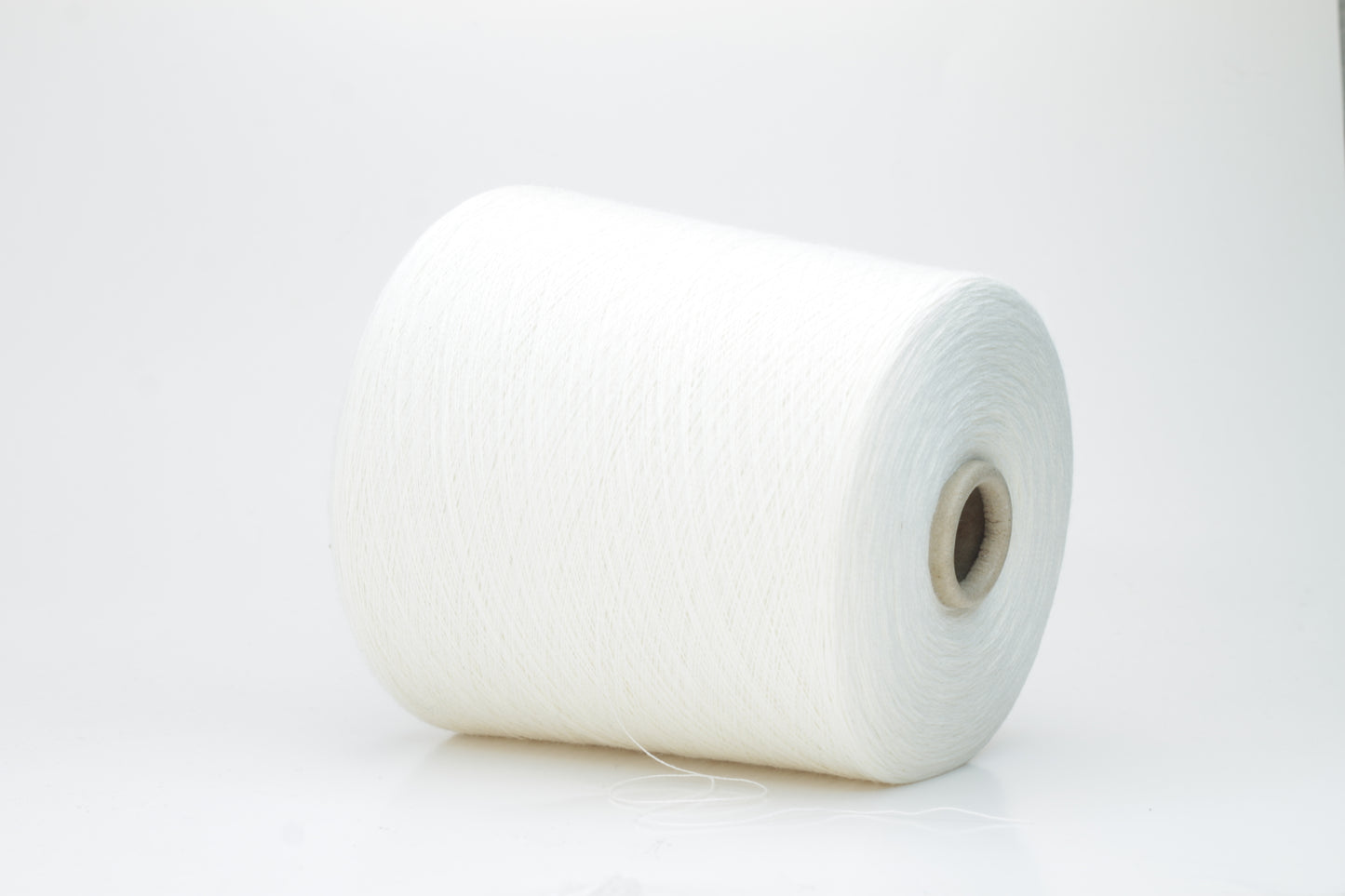 Close-up view of a creamy white, fluffy yarn strand with subtle sheen. The yarn shows a twisted ply construction and a dense, luxurious texture, hinting at its high cotton and cashmere fiber content.