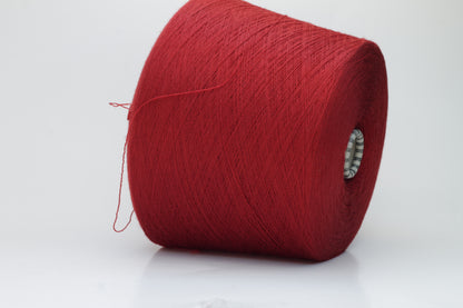 Close-up image of a vibrant red merino wool yarn skein, showcasing the smooth ply twist and subtle sheen reflecting light, with a fluffy texture.